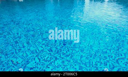 Acqua della piscina astratta. La piscina scorre con onde che fanno da sfondo alla piscina blu Foto Stock