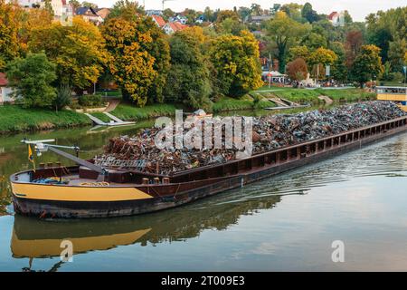 Settore dei trasporti. La chiatta della nave trasporta rottami metallici e sabbia con ghiaia. La chiatta caricata con rottami metallici si trova sulla strada Foto Stock