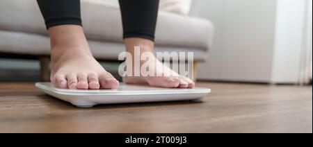 Dieta grassa e piedini graduati posizionati su bilance elettroniche per il controllo del peso. Strumento di misurazione in chilogrammi per il controllo della dieta. Foto Stock