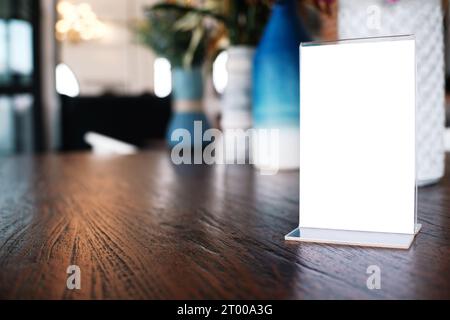 Telaio di menu in piedi sulla tavola di legno nel bar ristorante cafe. spazio per il testo marketing promozione Foto Stock