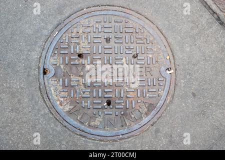 Una copertura per i Manhole della Round NYC nella città di New York Foto Stock