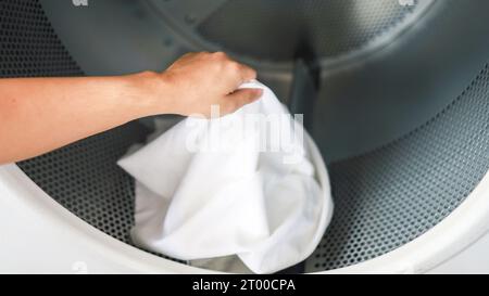 Uomo che fa lavare tenendo cesto con la lavanderia sporca della lavatrice nel negozio pubblico. concetto di lavanderia Foto Stock