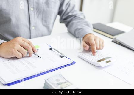 Uomo d'affari che controlla le bollette. imposte saldo del conto bancario e calcolo del bilancio annuale della società. Verifica contabile Foto Stock