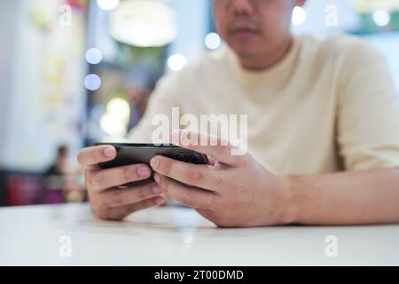 Uomo che gioca al telefono cellulare. Giocatore ragazzo che gioca ai videogiochi con SmartphoneÂ dispositivi mobili in funzione. tecn. telefono cellulare Foto Stock