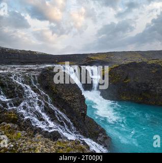 Pittoresca cascata Sigoldufoss vista autunno. Stagione che cambia nelle Highlands meridionali dell'Islanda. Foto Stock