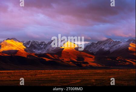 Tramonto sulle catene montuose innevate del Kirghizistan Foto Stock