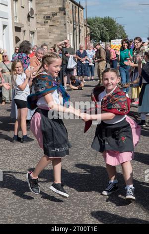 Cultura scozzese i bambini locali che partecipano a ballare per strada alla Cockenzie and Port Seton Friendly Society of Fishermen's Box Meeting Parade. Tradizionale ballo scozzese all'esterno del pub Thorntree. Cockenzie e Port Seton, East Lothian, Scozia. Settembre 2023 2020 UK HOMER SYKES Foto Stock