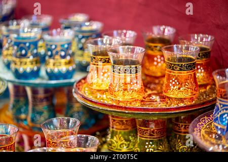 Bicchieri da tè marocchini su vassoi in diversi colori e dipinti splendidamente Foto Stock