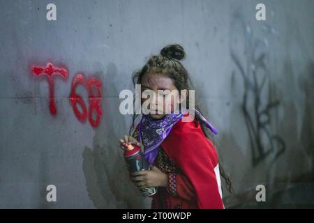 Messico, Messico. 2 ottobre 2023. Una ragazza dipinge un muro durante la 55a marcia commemorativa del massacro di Tlatelolco. La marcia commemora un altro anno del massacro studentesco avvenuto il 2 ottobre 1968 nell'area di Tlatelolco. Credito: SOPA Images Limited/Alamy Live News Foto Stock