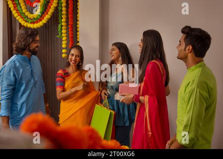 Gruppo di amici che arrivano a casa in occasione di Diwali Foto Stock