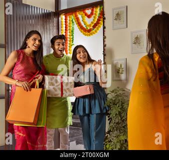 Gruppo di amici che arrivano a casa con regali in occasione di Diwali Foto Stock