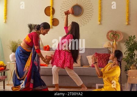 Famiglia bengalese che pratica dhunuchi a casa in occasione di Durga Puja Foto Stock