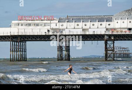 Brighton Regno Unito 3 ottobre 2023 - i nuotatori godono di una calda giornata di sole sulla spiaggia di Brighton, dato che si prevede che le temperature saranno insolitamente calde per il periodo dell'anno in alcune parti del paese: Credit Simon Dack / Alamy Live News Foto Stock