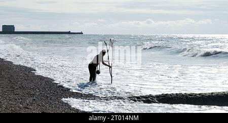 Brighton Regno Unito 3 ottobre 2023 - è il momento di fare una pagaia mentre i visitatori si godono una calda giornata di sole sulla spiaggia di Brighton, poiché si prevede che le temperature saranno insolitamente calde per il periodo dell'anno in alcune parti del paese: Credit Simon Dack / Alamy Live News Foto Stock