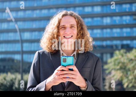 uomo d'affari moderno che usa il telefono cellulare all'aperto Foto Stock