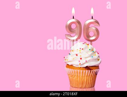 Torta di compleanno con candela numero 96 - su sfondo rosa. Foto Stock
