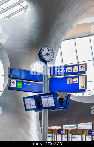 Cartello con indicazione di partenza e parcheggio dell'autobus con orologio all'interno della stazione centrale di Arnhem, Paesi Bassi Foto Stock