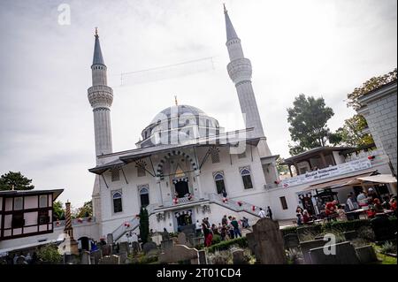 Berlino, Germania. 3 ottobre 2023. I visitatori della Moschea Sehetlik a Columbiadamm festeggiano l'uno con l'altro il giorno della Moschea aperta. Il giorno della Moschea aperta viene celebrato ogni anno nel giorno dell'unità tedesca. Credito: Fabian Sommer/dpa/Alamy Live News Foto Stock