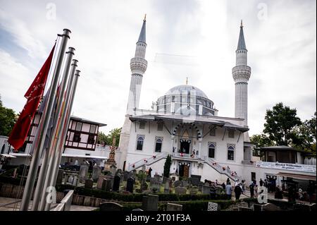 Berlino, Germania. 3 ottobre 2023. I visitatori della Moschea Sehetlik a Columbiadamm festeggiano l'uno con l'altro il giorno della Moschea aperta. Il giorno della Moschea aperta viene celebrato ogni anno nel giorno dell'unità tedesca. Credito: Fabian Sommer/dpa/Alamy Live News Foto Stock