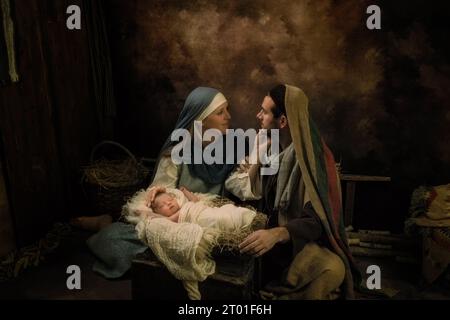 Coppia riemanare una scena di Natale dal vivo con il loro bambino neonato di 8 giorni Foto Stock