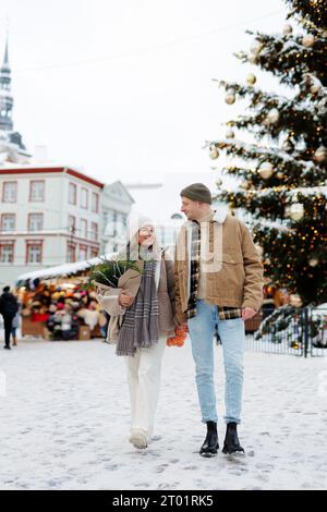 Coppia felice che cammina al mercatino di natale in inverno Foto Stock