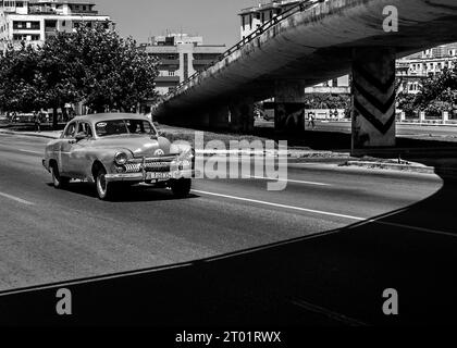 Auto d'epoca americana, guida sotto il ponte del cavalcavia, l'Avana, Cuba. Foto B&N. Foto Stock