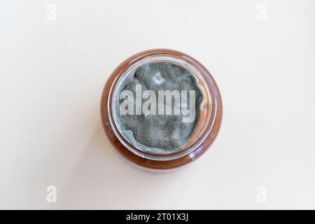 Aprire il vaso con marmellata dolce e muffa su sfondo bianco. Foto Stock