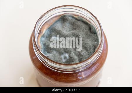 Aprire il vaso con marmellata dolce e muffa su sfondo bianco. Foto Stock