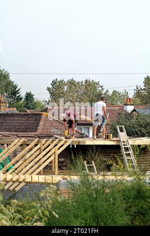 Costruttori che lavorano su un'estensione del tetto di un bungalow suburbano a Shepperton, Surrey, Inghilterra, Regno Unito Foto Stock