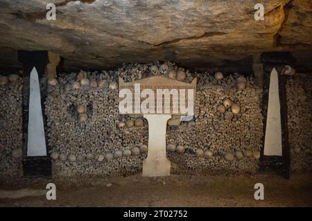 Nelle Catacombe di Parigi, un lungo percorso sotterraneo con strutture formate da ossa umane, vicino a Montparnasse, Parigi, Francia Foto Stock