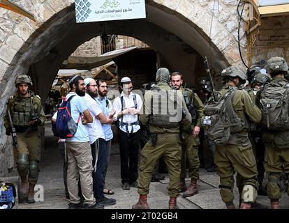 Hebron, Cisgiordania. 3 ottobre 2023. I soldati israeliani proteggono i turisti ebrei che visitano il mercato palestinese durante il festival ebraico di Sukkot, la festa dei Tabernacoli, a Hebron, Cisgiordania, martedì 3 ottobre, 2023. foto di Debbie Hill/ Credit: UPI/Alamy Live News Foto Stock