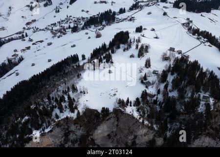 Foto di un drone nelle Alpi svizzere su un lago chiamato Walensee e sullo sfondo le vette delle montagne sono illuminate dal sole del mattino. Foto Stock