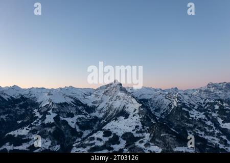 Foto di un drone nelle Alpi svizzere su un lago chiamato Walensee e sullo sfondo le vette delle montagne sono illuminate dal sole del mattino. Foto Stock
