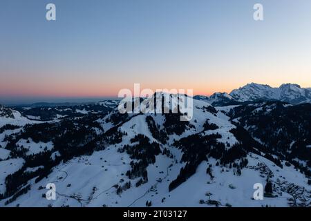 Foto di un drone nelle Alpi svizzere su un lago chiamato Walensee e sullo sfondo le vette delle montagne sono illuminate dal sole del mattino. Foto Stock