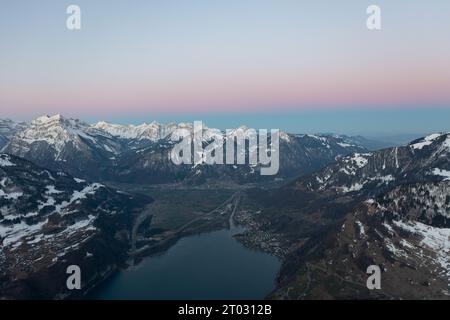 Incredibile alba con un orizzonte rosa sulle cime delle Alpi svizzere sopra un lago di montagna nel Canton Glarona. Foto Stock