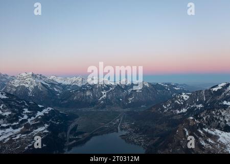 Incredibile alba con un orizzonte rosa sulle cime delle Alpi svizzere sopra un lago di montagna nel Canton Glarona. Foto Stock