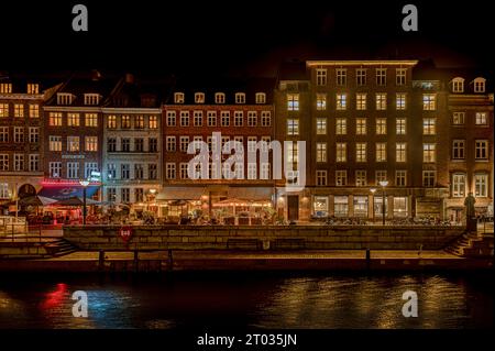 Molo di legno vicino al canale Slotsholm a Copenaghen, dove le case si riflettono nell'acqua calma di notte, Danimarca, 2 ottobre 2023 Foto Stock