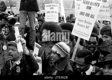 la marcia per il lavoro del reverendo Jesse Jackson -- 1975 USA. Jesse Jackson circondato da manifestanti che portavano cartelli che sostenevano il sostegno alla legge Hawkins-Humphrey per la piena occupazione. Foto Stock