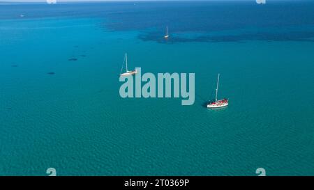 Yacht vicino alla spiaggia di Spiagga la Pelosa nel nord-ovest della Sardegna. Comune di Stintino, provincia di Sassari, Sardegna, Italia. Estate, giorno di sole, blu Foto Stock