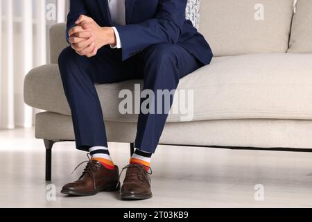 Uomo che indossa scarpe eleganti e calze colorate al chiuso, primo piano Foto Stock