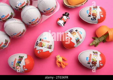 Sveti Vlas, Bulgaria - 26 giugno 2023: Uova a sorpresa Kinder, contenitori di plastica e giocattoli su sfondo rosa, deposizione piatta Foto Stock