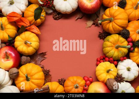 Giorno del Ringraziamento. Montatura con zucche e mele su sfondo marrone, base piatta. Spazio per il testo Foto Stock