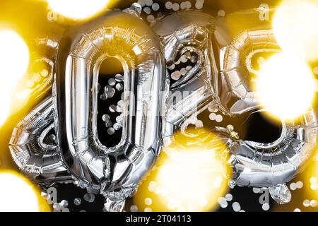 Palloncini metallizzati garland Happy New Year 2025 con coriandoli su sfondo nero scuro. Biglietti d'auguri palloncini in alluminio argentato numeri concetto natalizio. Decorazione di congratulazioni per la festa di celebrazione Foto Stock