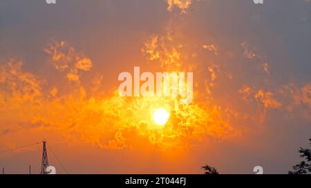 Spettacolare tramonto o cielo all'alba. Nuvole con i raggi del sole. Splendido panorama panoramico della forte alba con il rivestimento argentato e nuvole sull'arancia Foto Stock