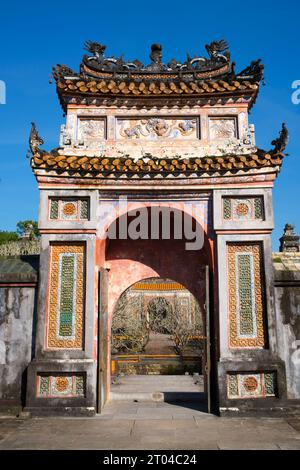 Vietnam: Porta ornamentale presso la tomba dell'imperatore tu Duc, Hue. Tự Đức (22 settembre 1829 – 17 luglio 1883) (nome completo: Nguyễn Phúc Hồng Nhậm, anche Nguyen Phuc Thi) è stato il quarto imperatore della dinastia Nguyễn del Vietnam e regnò dal 1847 al 1883. Figlio dell'imperatore Thiệu Trị, il principe Nguyễn Phúc Hồng Nhậm succedette al padre sul trono, con il titolo regnante di Tự Đức, ma i problemi familiari causarono un inizio violento della sua epoca. Thiệu Trị aveva passato il figlio maggiore più moderato, Hồng Bảo, per dare il trono a Tự Đức. Foto Stock