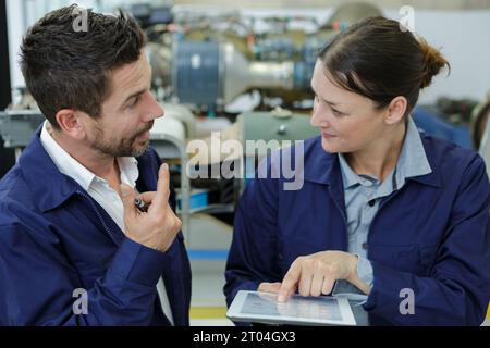 2 lavoratori che discutono vicino alla fabbrica Foto Stock