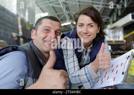 team di meccanici sorridenti alla macchina fotografica presso il garage di riparazione Foto Stock