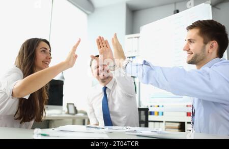 Un team di dipendenti molto gioiosi offre cinque successi per festeggiare Foto Stock