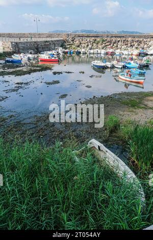 Il molo dei pescatori nel porto di Pozzuoli è rimasto quasi privo di acqua di mare a causa del bradicardia che in questo periodo si sta intensificando in tutta la zona dei campi Flegrei, che poggia sulla caldera più grande d'Europa. Il bradicseismo fa sì che la terra si innalzi e, in questo caso, le barche dei pescatori sono rimaste asciutte a terra. Foto Stock