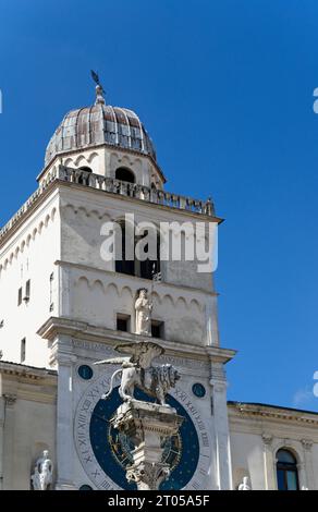 Primo piano della colonna con il Leone di St Segnate nel centro storico di Padova, sullo sfondo l'orologio astronomico medievale in Italia Foto Stock